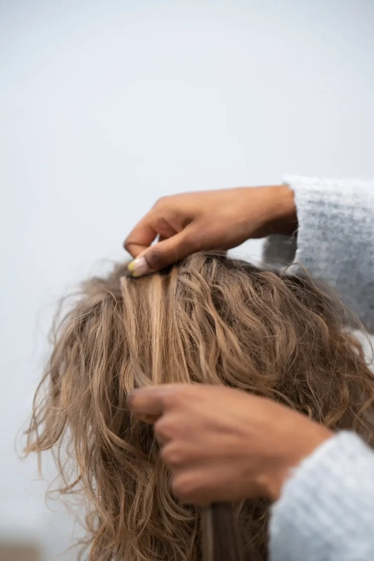 Stylistin prüft die Haarstruktur vor der Beratung